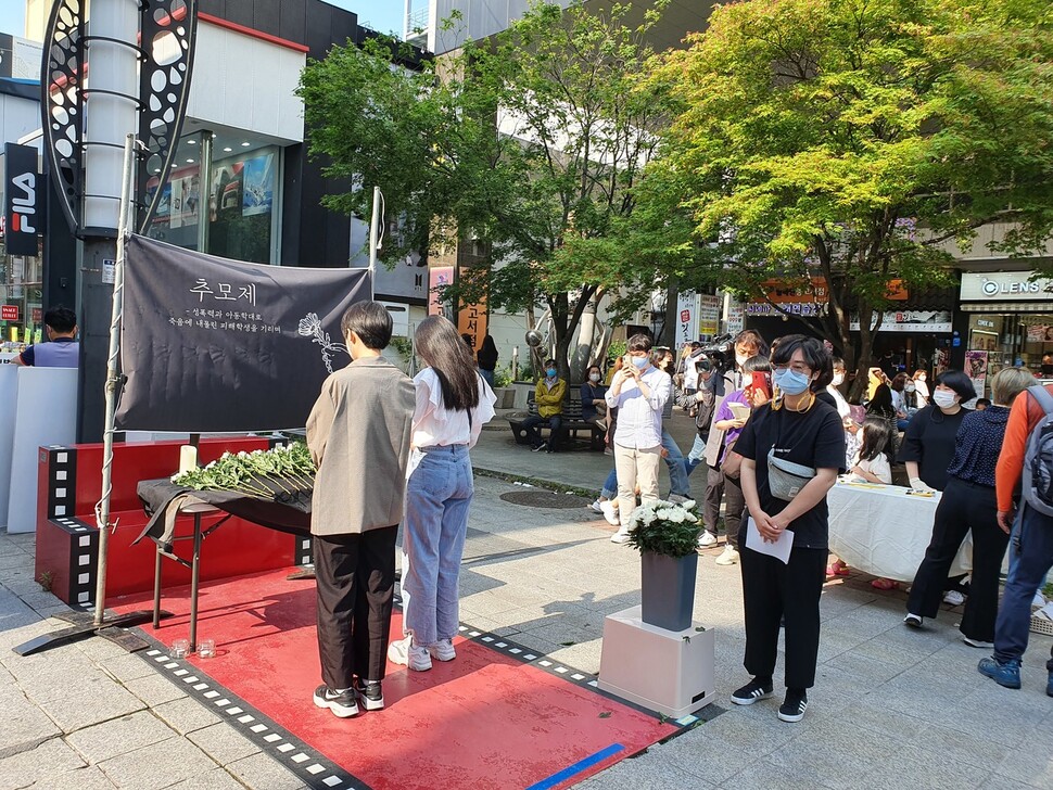 시민들이 지난 22일 청주 성안길에서 열린 청주 중학생 추모제에서 헌화·묵념하고 있다.