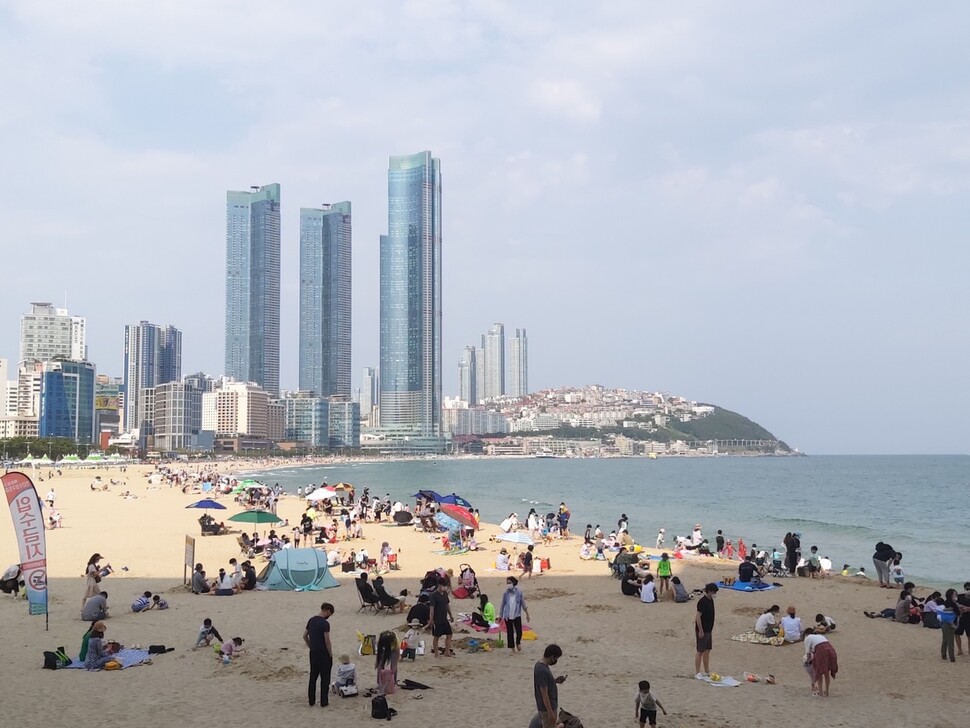 부산 해운대해수욕장에서 시민들이 피서를 즐기고 있다. 대형 건물 3채가 엘시티다.