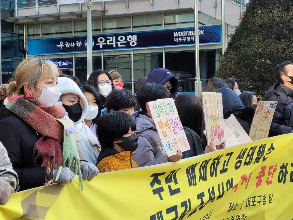 16일 오전 서울환경운동연합을 비롯한 27개 단체는 서울 마포구청 앞에서 ‘성미산 데크길 조성사업 중단 촉구 기자회견’을 열었다. 종이박스 위에 쓴 ‘성미산과 함께 살아요 새·나무·사람’이라는 문구가 보인다. 김양진 기자