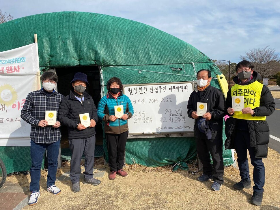 지난달 28일 책 &lt;원전마을&gt;을 기획한 이상홍 경주환경운동연합 사무국장(맨 오른쪽)과 저자 김우창씨(맨 왼쪽)가 주민들을 만나 책을 전달했다. 김우창씨 제공