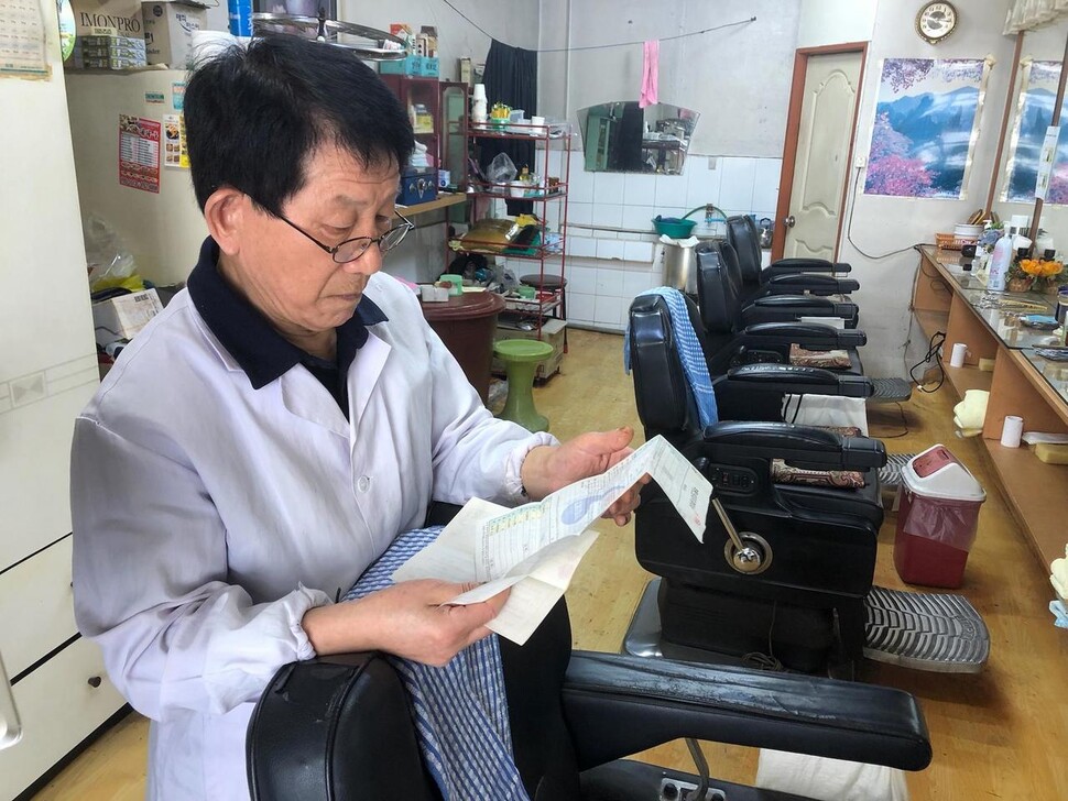 지난달 31일 유병두씨가 대흥이발관 임대차계약 서류를 보고 있다. 이승욱 기자