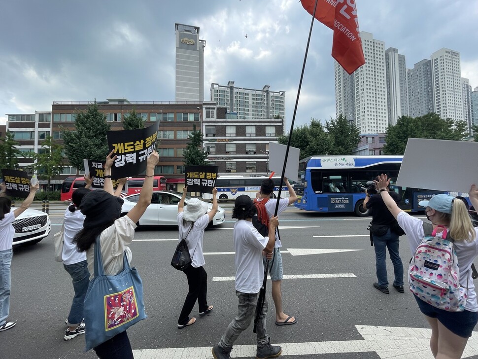 ‘개 식용 종식 촉구’ 집회 행렬을 본 용산 시민이 창밖으로 강아지들과 함께 손을 흔들며 응원을 보내고 있다. 김지숙 기자