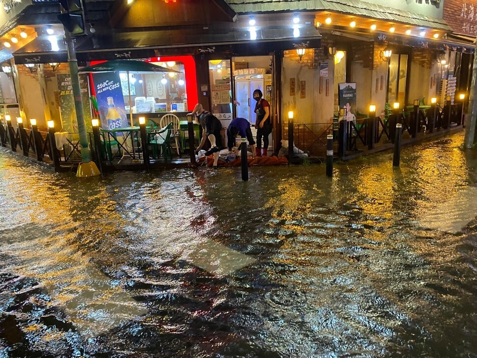 지난 10일 밤 집중호우로 충북 청주시 복대동 일대 도로 등이 침수되자 주민 등이 배수에 안간힘을 쓰고 있다. 충북소방본부 제공