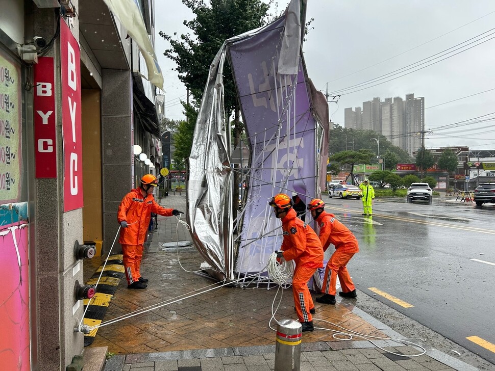 태풍 ‘카눈’이 한반도를 통과한 10일 아침 전남 화순군 화순읍의 한 건물 간판이 떨어져 119대원들이 안전조치하고 있다.전남소방본부 제공