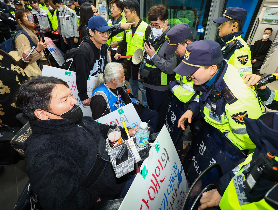 전국장애인차별철폐연대(전장연) 회원들이 9일 오전 서울역 공항철도 승강장에서 비행기 탑승권리 선전전을 위해 인천국제공항 제1여객터미널로 이동하기에 앞서 팻말을 제거하고 탑승하라는 공항철도 및 경찰들과 대치하고 있다. 연합뉴스