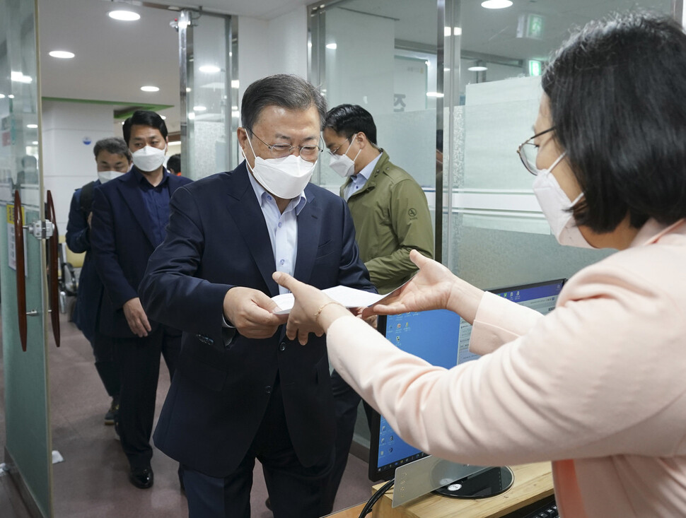 문재인 대통령이 25일 서울 종로구 보건소에서 코로나19 백신 4차 접종에 앞서 안내문을 받고 있다. 청와대사진기자단