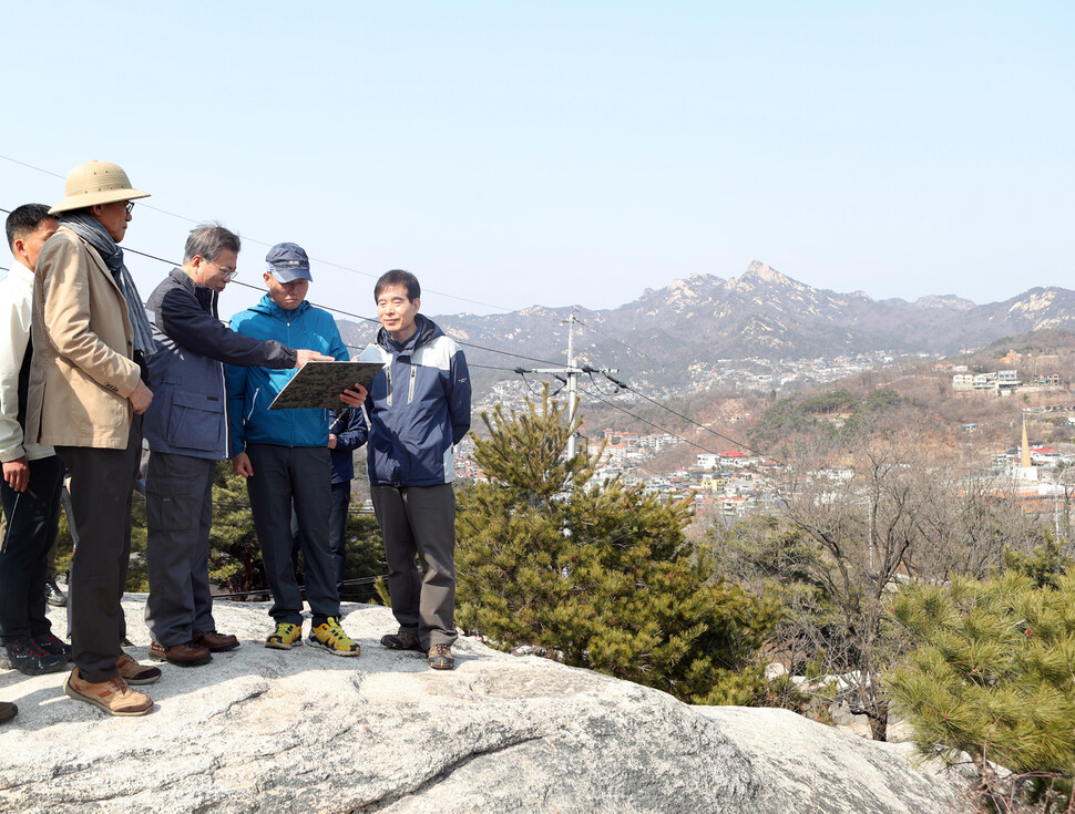 1968년 1·21 사태 이후 청와대 방호 목적상 일반인에 대해 부분 통제되었던 인왕산 지역이 50년 만에 완전 개방된다고 2018년 5월 3일 청와대가 밝혔다. 이는 문재인정부의 ‘열린 청와대’ 방침에 따라 청와대 앞길 24시간 개방에 이어 추진된 추가 조치였다. 사진은 문재인 대통령이 2018년 3월 10일 유홍준 전 문화재청장, 건축가 승효상 동아대 석좌교수 등과 함께 인왕산 탐방로를 둘러보는 모습이다. 청와대 제공