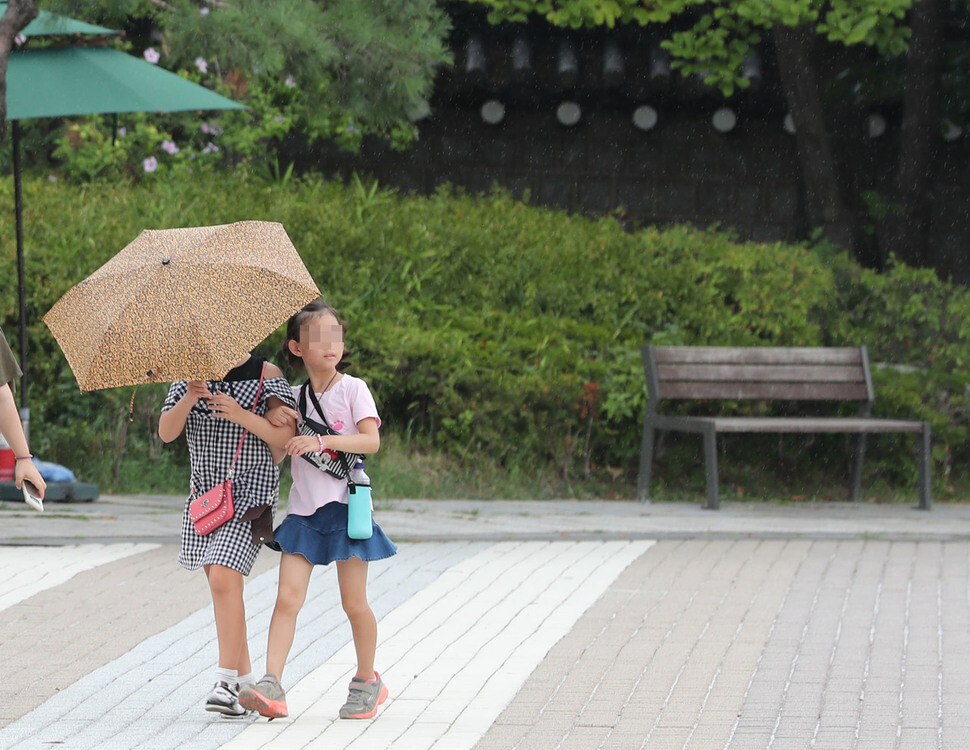 9일 오후 청와대 앞길에서 두 어린이가 우산을 함께 쓰며 소나기를 피하고 있다. 백소아 기자 thanks@hani.co.kr