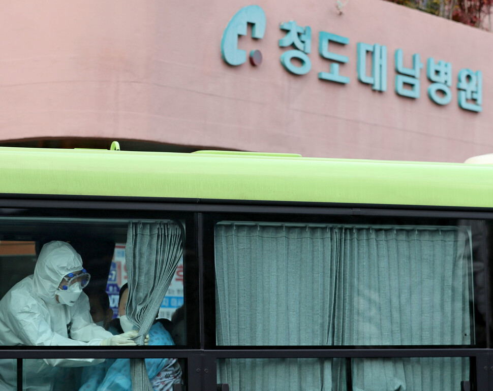 지난달 27일 경북 청도대남병원에서 서울 국립정신건강센터로 이동하는 환자 이송 버스 안에서 한 의료진이 커튼을 치고 있다. 연합뉴스