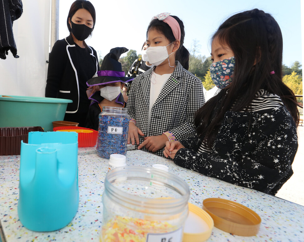 24일 오전 서울 마포구 문화비축기지공원에서 열린 ‘플라스틱 프리 페어’에서 어린이들이 플라스틱을 직접 수거해 소재화해 만든 대형 책상 앞에서 원료로 쓰인 플라스틱을 살펴보고 있다. 김태형 기자