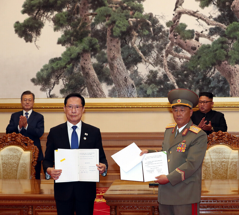 2018년 9월19일 북한 평양 백화원영빈관에서 송영무 국방부 장관(앞줄 왼쪽)과 노광철 북한 인민무력상(앞줄 오른쪽)이 군사 분야 합의문 서명식을 마친 뒤 기념사진을 찍기 위해 합의문을 들어 보이고 있다. 두 사람 뒤에서 문재인 대통령과 김정은 북한 국무위원장이 박수를 치고 있다. 평양사진공동취재단/김정효 기자 hyopd@hani.co.kr