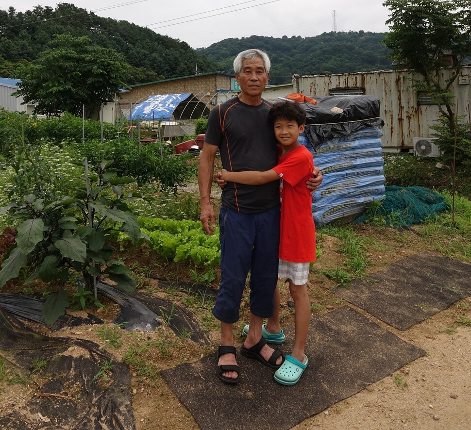 2023년 7월2일 오후 김재훈씨가 경기도 파주 조리읍 장곡3리 컨테이너 농막 앞에서 손주 산이와 사진을 찍고 있다. 김양진 기자