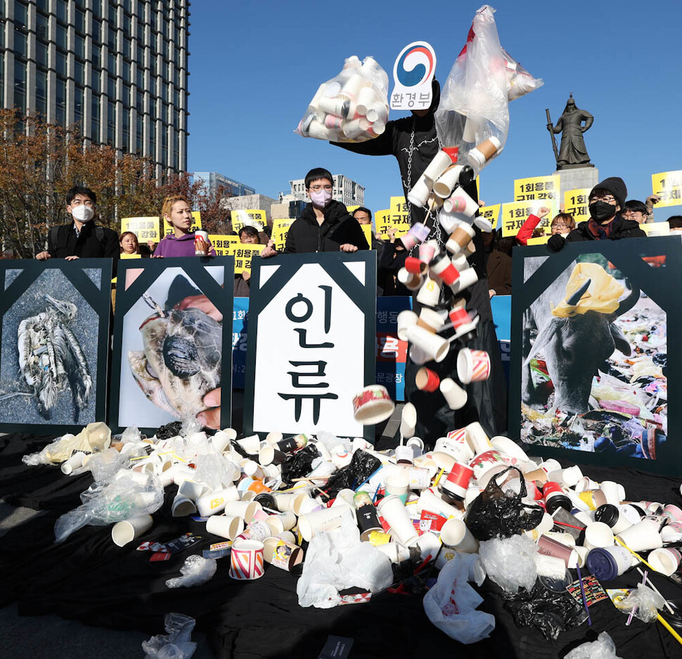 ‘1회용품 사용 규제 철회 규탄 전국공동행동’ 참여단체 활동가들이 21일 오전 서울 광화문광장에서 환경부가 환경을 파괴하는 1회용품 쓰레기를 둘러싸여 있는 모습을 나타내는 행위극을 하고 있다. 김정효 기자