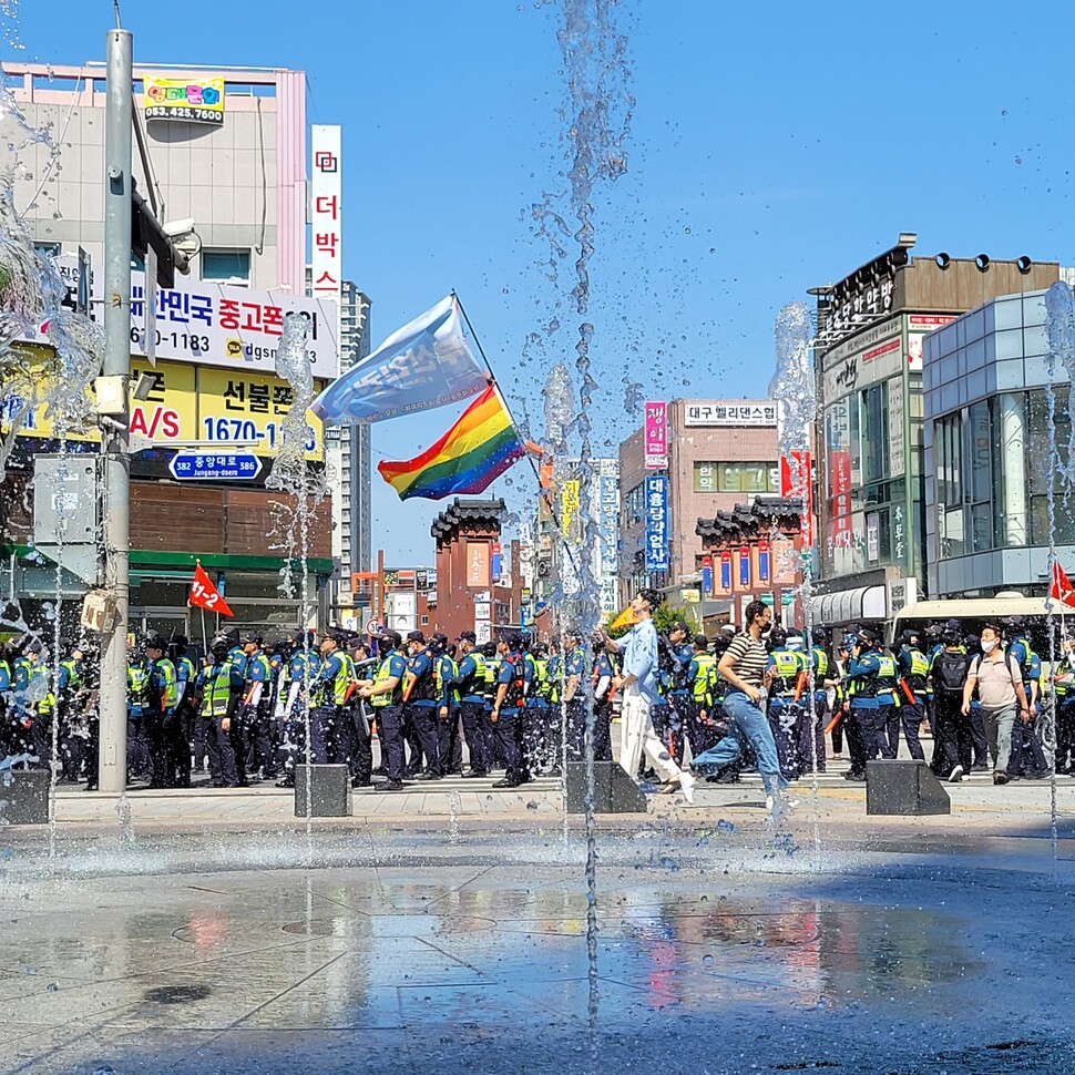 대구퀴어문화축제가 열리는 17일 오전 주최 측의 대중교통전용지구 도로 사용 여부를 놓고 경찰과 행정 당국이 충돌하는 가운데 행사 참가자가 무지개 깃발을 들고 걸어가고 있다. 연합뉴스