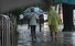 장맛비가 내리는 23일 오후 서울 서대문구 미근동 거리에서 우비를 입은 한 시민이 맨발로 길을 걷고 있다. 2022.6.23 연합뉴스