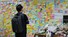 ‘역무원 스토킹 피살 사건’이 발생한 서울지하철 2호선 신당역 화장실 입구에 마련된 추모공간에서 19일 한 시민이 벽면을 가득 채운 메시지들을 살펴보고 있다. 연합뉴스