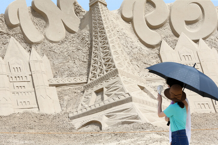 경북 포항에 폭염특보가 발령된 가운데 17일 포항 북구 두호동 영일대해수욕장에 설치된 프랑스 에펠탑 모래조각을 피서객이 둘러보고 있다. 연합뉴스