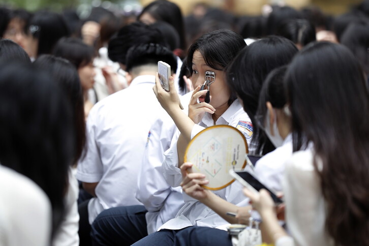 새 학기 첫날인 5일 베트남 하노이의 한 고등학교에서 한 학생이 학교 운동장에 앉아 속눈썹을 다듬고 있다. 이날 베트남에서는 2천2백만 명 이상의 학생이 새 학년을 시작했다. EPA 연합뉴스