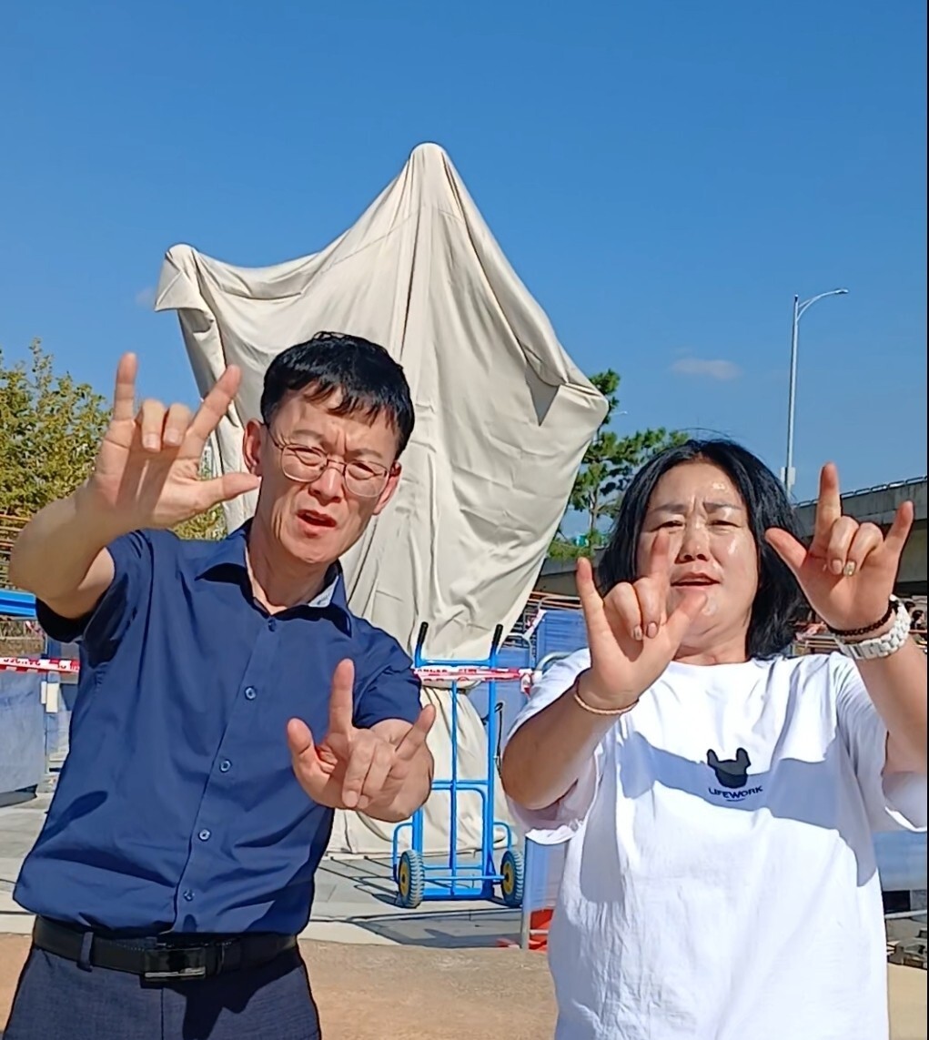 20일 인천 송도국제도시 롱비치파크의 조형물 앞에서 ‘사랑해’를 수어로 말하고 있는 이주순 인천농아인협회 연수구지회장(오른쪽)과 남편인 정택진 수어통역사. 인천농아인협회 연수구지회 제공