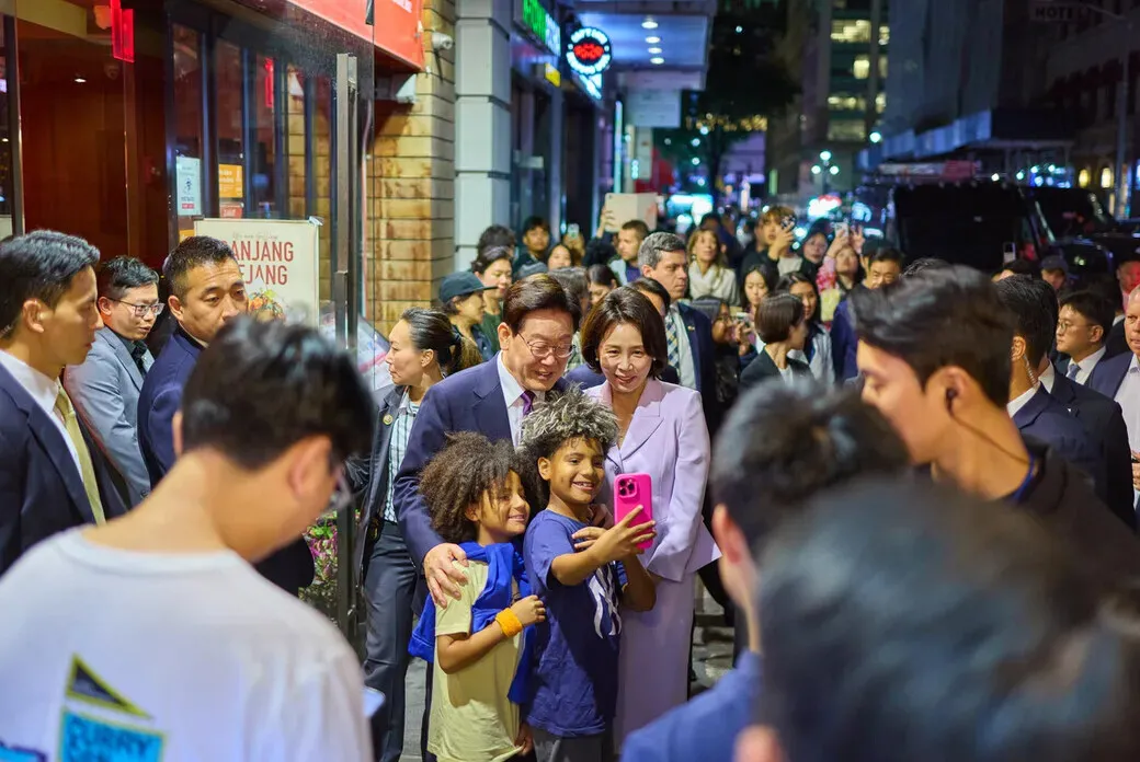 President Lee Jae Myung and first lady Kim Hae-kyung take a photo with two kids while visiting New York’s Koreatown on Sept. 21, 2026. (pool photo)