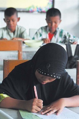 나라티왓 초아이롱 지구의 한 공립학교에서 무슬림 소녀가 불교도인 동급생들과 어울려 수업을 듣고 있다.