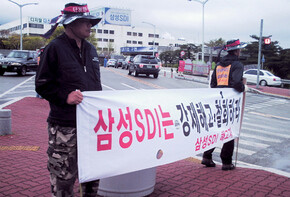 울산 삼성SDI 사내기업 해고자들이 삼성SDI 사업장 앞에서 사내기업 비정규직 노동자의 해고를 철회하라고 요구하는 펼침막을 들고 있다. 삼성SDI 사내기업 해고자 복직투쟁위원회 제공