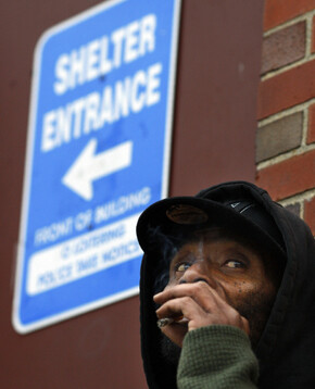 지난 11월18일 미 동부 로드아일랜드주 크랜스턴 지역의 쉼터 앞에서 한 노숙인이 처연한 표정으로 담배를 피워물고 있다. REUTERS / BRIAN SNYDER