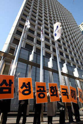  2007. Protesters hold picket signs that means “Dissolve the republic of Samsung.”