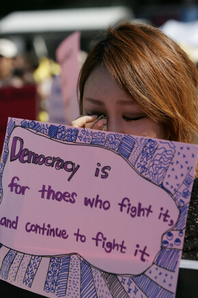 2009년 8월23일 서울시청 앞 광장에서 열린 김대중 전 대통령 노제에서 민주주의를 가꾸기 위해 시민의 참여가 중요하다는 내용의 손팻말을 든 젊은 여성이 눈물을 훔치고 있다. <한겨레21> 박승화 기자