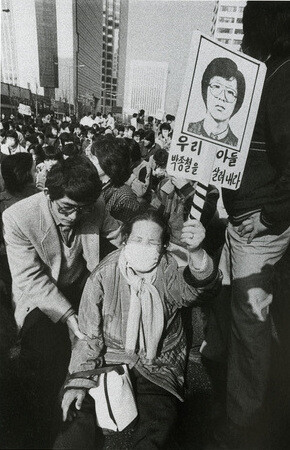 박종철군 고문치사 사건 직후 서울 광교 근처에서 한 할머니가 그의 영정을 들고 책임자 처벌을 요구하고 있다. 한겨레 자료