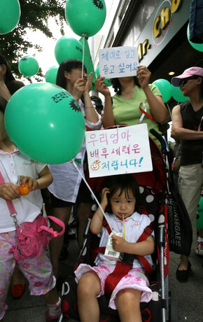  an Internet community for cuisine demonstrate against what they see as distorted coverage of the candlelight protests in the Chosun Ilbo in front of the Koreana Hotel in Seoul on June 22. The sign attached to the baby carriage says