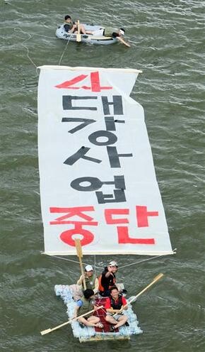 진보신당 부산시당 당원들이 8월9일 오전 낙동강 하류 부산 구포대교 근처에서 4대강 사업을 중단하라는 퍼포먼스를 벌이고 있다. 이들이 탄 뗏목은 페트병 420여 개를 이어 한 달 동안 만든 것으로 4대강 사업의 허구성을 상징한다. 사진 연합 김선호