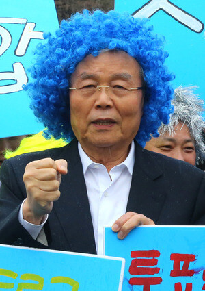 Minjoo Party of Korea leader Kim Jong-in wears a blue wig while saying “Let’s vote” in a campaign event supporting candidate Jin Sung-joon