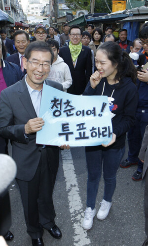 박원순 서울시장 범야권 단일후보가 19일 오후 서울 마포구 공덕동 공덕시장을 찾아 지지를 호소하던 중 박후보를 만나기 위해 휴가를 내고 찾아왔다는 한 시민과 청년층의 투표참여를 독려하는 손팻말을 들고 사진을 찍고 있다. 김정효 기자 hyopd@hani.co.kr