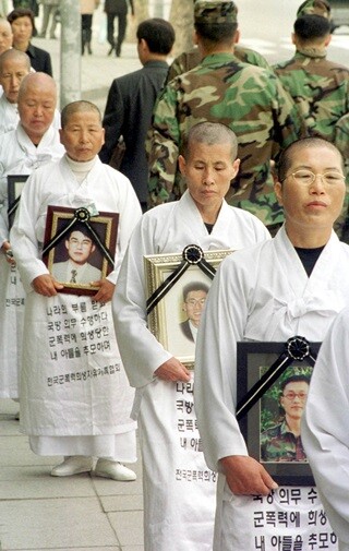 2000년 10월 서울 용산구 국방부 앞에서 ‘전국군폭력희생자유가족협회’ 회원들이 군에서 의문사한 아들의 영정을 들고 삭발한 채 진상 규명을 요구하는 시위를 하고 있다. 한겨레 김정효 기자