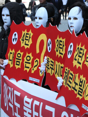  Korean anti-nuclear activists hold a demonstration in front of the Nuclear Safety Commission building. The protesters’ signs mention nuclear crisis in Three Mile Island