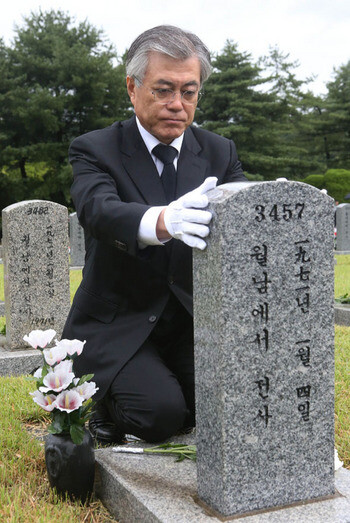 Moon Jae-in lays a chrysanthemum at the grave of a South Korean soldier who died in the Korean War
