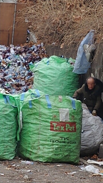 2018년 3월8일 서울시 장애인인권센터에 응급구조되기 전, 신씨가 서울 송파구 잠실야구장 적환장(주변 쓰레기를 모아두는 곳)에서 쓰레기를 정리하고 있다. 장애우권익문제연구소 제공