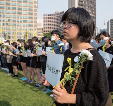 Yong Hye-in participates in a silent demonstration that she initiated with other young people after the Sewol tragedy in April. The signs read