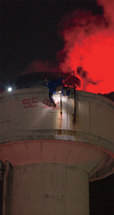 지난 3월14일 ‘희망행동’ 행사가 끝날 무렵 쌍용자동차 평택공장 굴뚝 위에서 이창근(전 쌍용차지부 정책기획실장)씨가 분필로 “또 와요”란 글자를 쓰고 있다. 박승화 기자