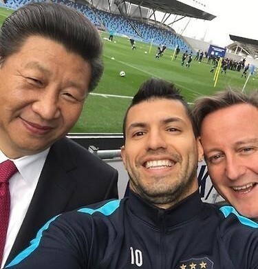O presidente chinês Xi Jinping (à esquerda), visitando a Grã-Bretanha, posa para uma selfie com Sergio Aguero (centro) e o primeiro-ministro britânico David Cameron no estádio de treinamento do Manchester City em 23 de outubro de 2015. Yonhap News