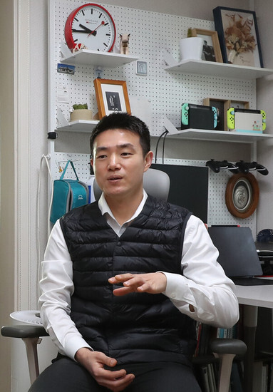 Kim Su-yeong sits at his desk in his home, a unit in a multifamily housing building he lives in on a jeonse key money contract, in Seoul’s Jungnang District on Dec. 30. (Shin So-young/The Hankyoreh)