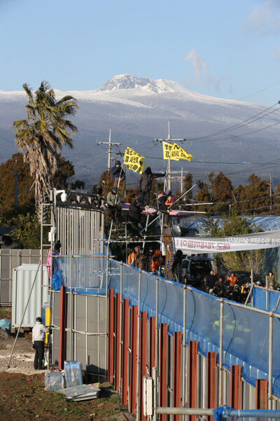  Jan. 31. Snowcapped Halla Mountain is seen in the background. They were talked down 14 hours later after some scuffles with police. (by Kim Bong-kyu