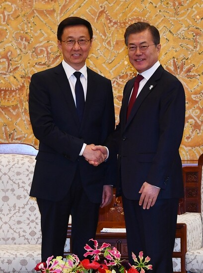 President Moon Jae-in shakes hands with Chinese Politburo Standing Committee member and special envoy for President Xi Jinping