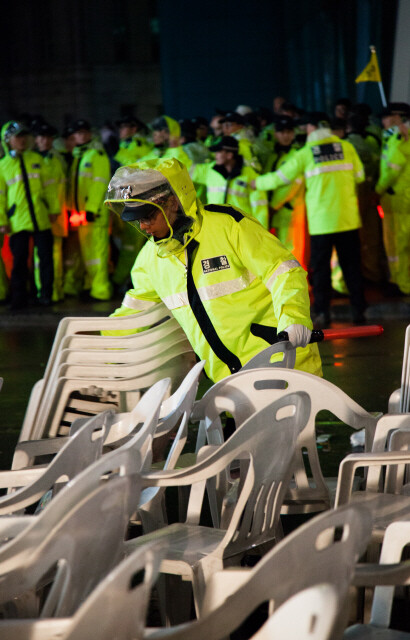 집회가 끝난 뒤 의자를 치우며 뒷정리를 도와주는 경찰. 11월9일 서울시청 앞.