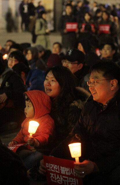 » 지난 4월4일 저녁 서울 대한문 앞에서 열린 ‘불법사찰 및 은폐 규탄 국민 촛불집회’에 참석한 한 가족이 촛불을 켜들고 있다. <한겨레> 이정우