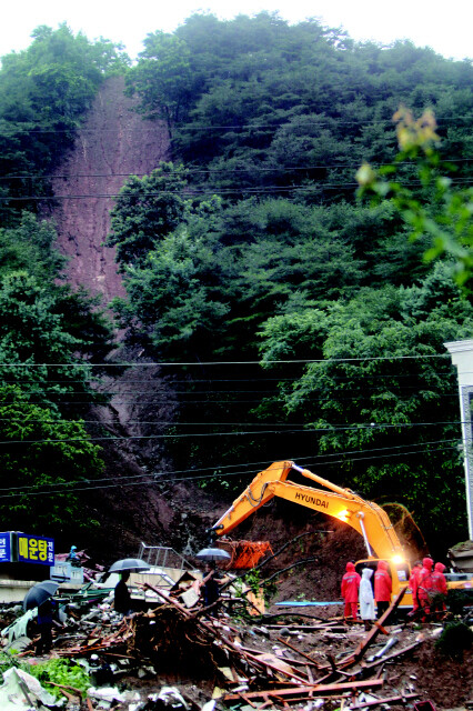 » 지난 7월27일 폭우가 내리는 가운데 강원 춘천시 신북읍 천전리 인근 산사태로 매몰된 건물에서 119 구조대원이 매몰자를 수색하고 있다. 한겨레 이종근