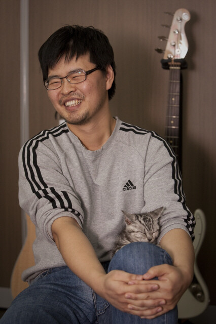 윤필씨가 작업실을 같이 쓰는 만화가 ‘HUN’씨의 고양이를 무릎에 앉히고 이야기를 하고 있다.