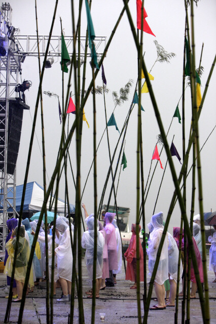 우비를 입은 청중이 폭우가 쏟아지는 물양장부지에서 인디밴드의 공연을 즐기고 있다.