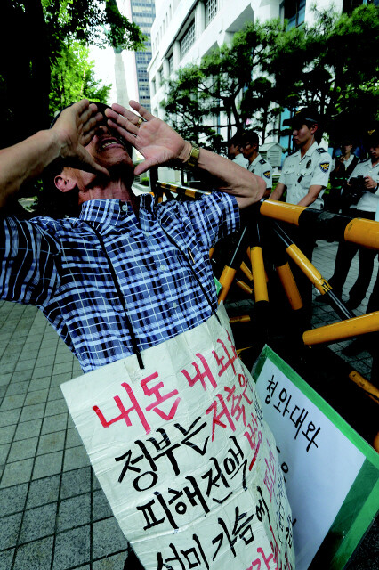 금융소비자 단체가 7월24일 서울 여의도 금융위원회 앞에서 CD 금리 담합 의혹과 관련해 금융소비자 보호를 촉구하는 기자회견을 열자 저축은행 피해자인 안치웅(73)씨가 